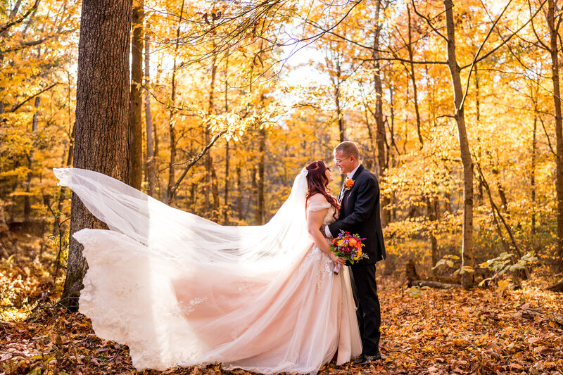 Columbus area bride and groom, Sydney and Kevin face each other while Sydney's wedding gown swooshes. - Cheers Chalet Lancaster Ohio