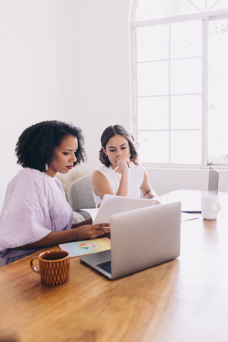 two women at table looking at papers