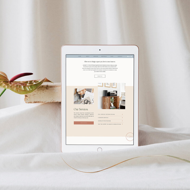 Interior design website on a white iPad on top of a white sheet