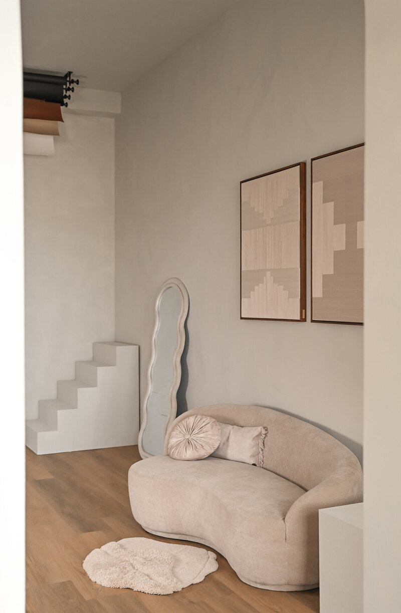 tijlvolle setting in Studio Laurant met een sofa, grote spiegel, kunstwerk en achtergrondrollen voor een veelzijdige en creatieve sfeer.