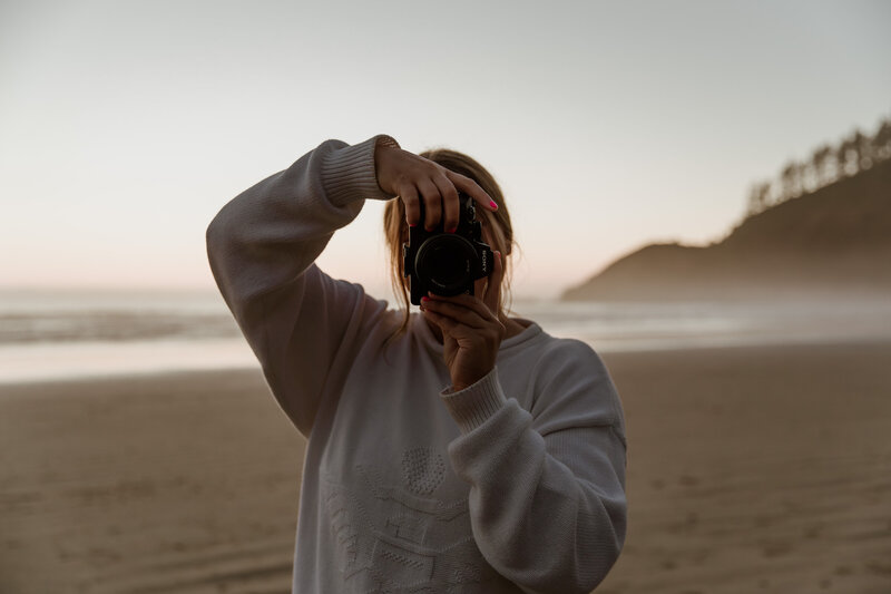 Mattie Nelson posing with camera for branding photos on the Oregon coast.