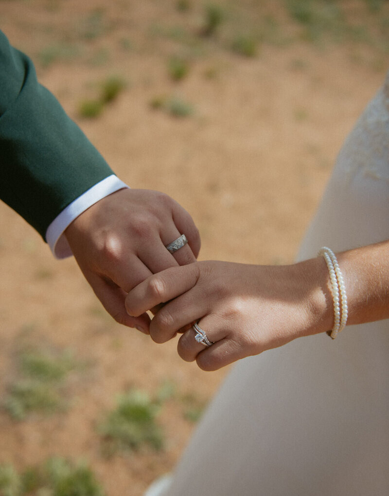 A couple holding hands and showing their rings after their Colorado elopement ceremony