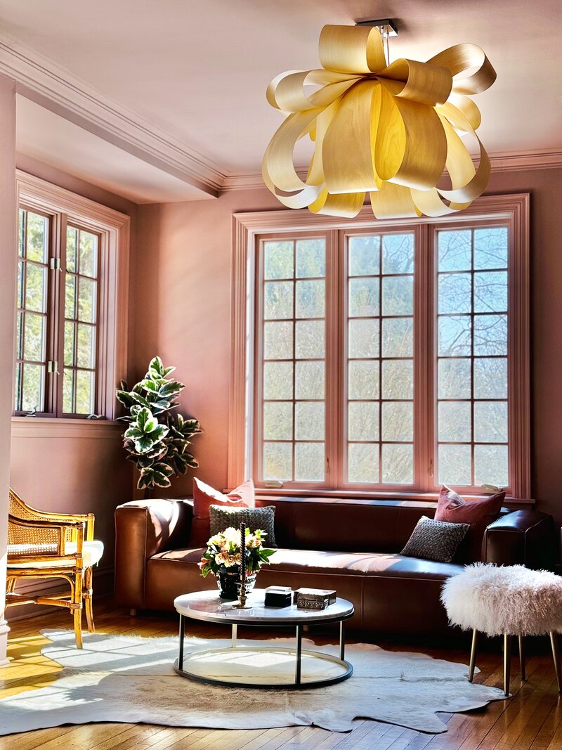 pink-sitting-room-with-leather-couch-wooden-chandelier