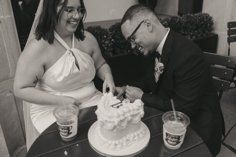 bride and groom laughing with cake after eloping shot by Elsie Goodman Photography | NYC Elopement Packages