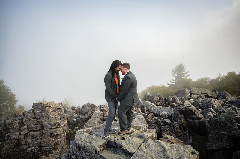 A couple stands on top of a large rock pile at Blackrock Summit in Shenandoah National Park.