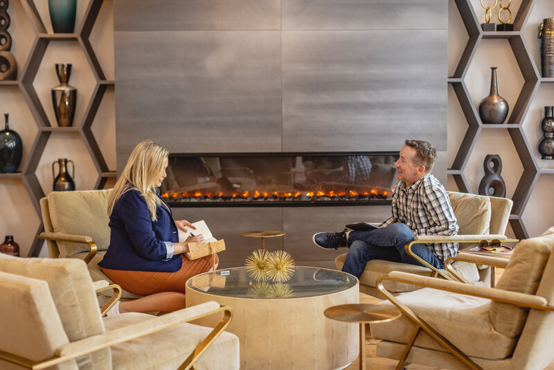 man and woman talking in front of fireplace