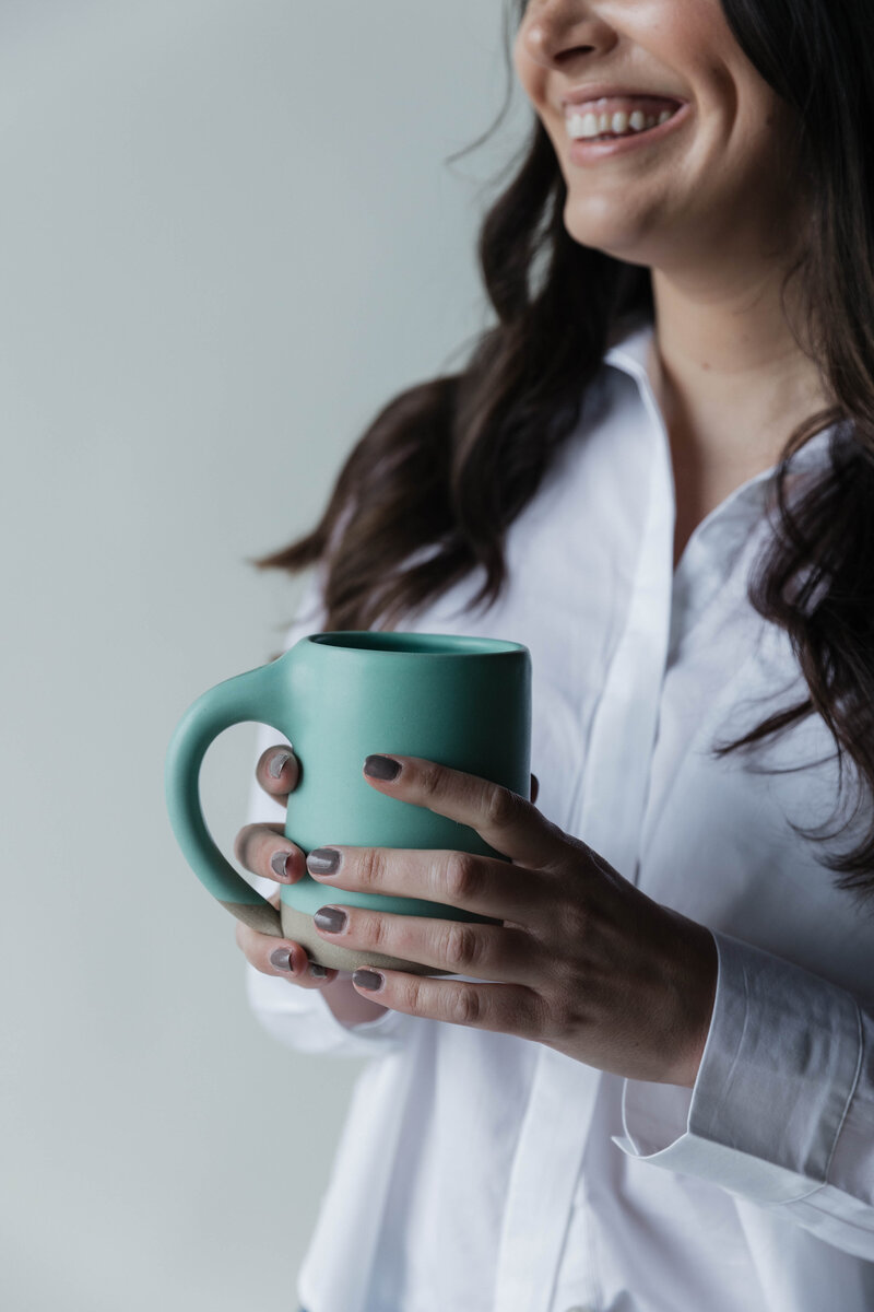 Therapist holding a blue cup of coffee