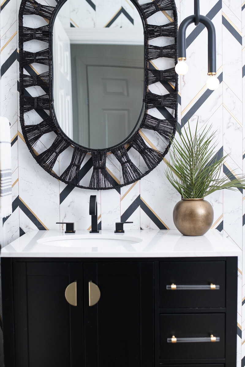 bathroom wiht black and white color scheme and gold accents
