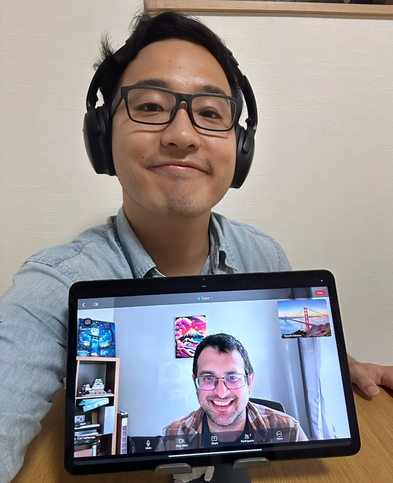 Yasushi smiling with a student during a virtual Japanese language lesson via tablet