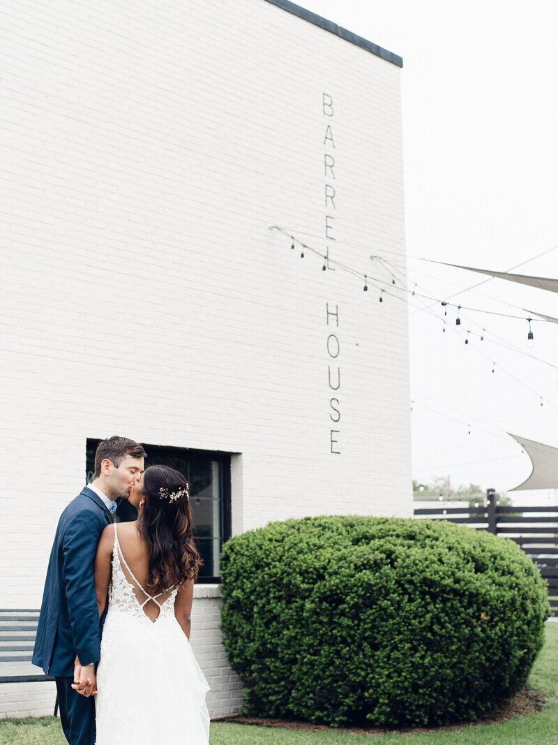 couple kissing in front of barrel house taken by wedding photographer frederick md Nicole Simensky