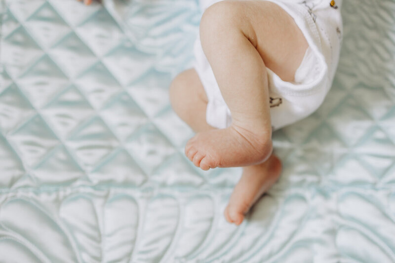 Baby legs and feet on a quilt