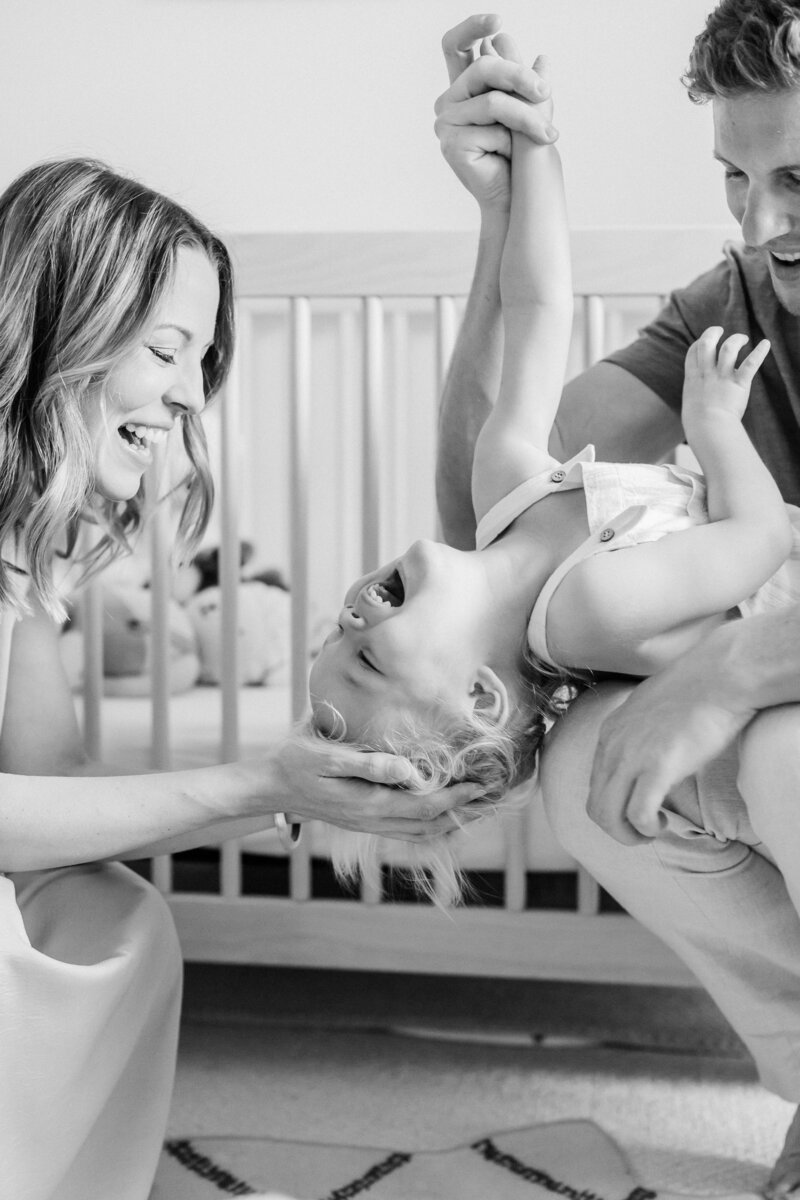mom and dad laughing with toddler by Orlando in-home family photographer