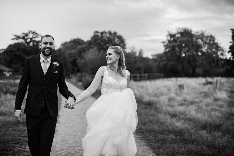 Bride and groom walking through fields