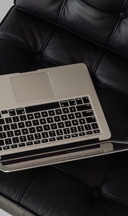 laptop on black leather chair