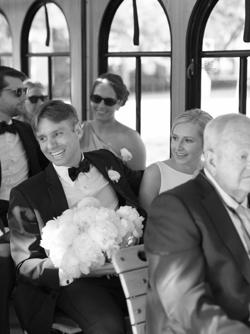 Bride and groom ride in a trolley with their wedding parties from ceremony to reception