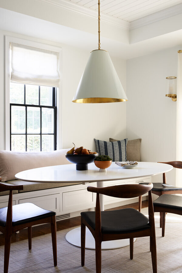 A modern dining table complements historic architecture in a Boston home, part of a renovation and new construction project by a Boston-area interior designer.