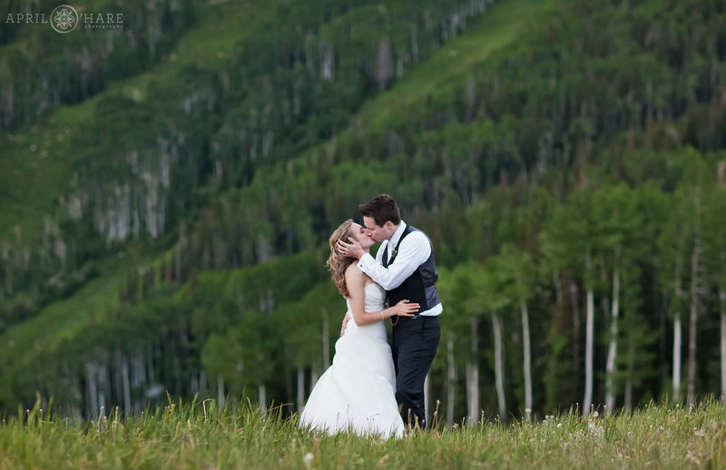 Couple smooches in the pretty aspen tree scenery at Thunderhead Lawn in Steamboat Springs Colorado