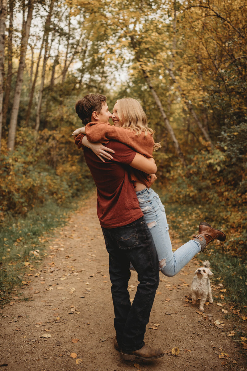 Photo of engaged couple in fall leaves