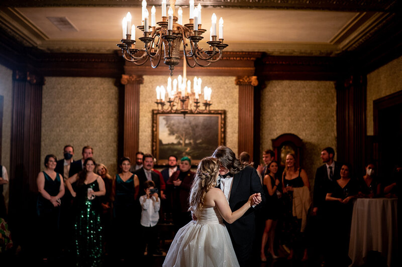 San Francisco wedding photographer captures first dance at University Club with ornate chandeliers and classic interior