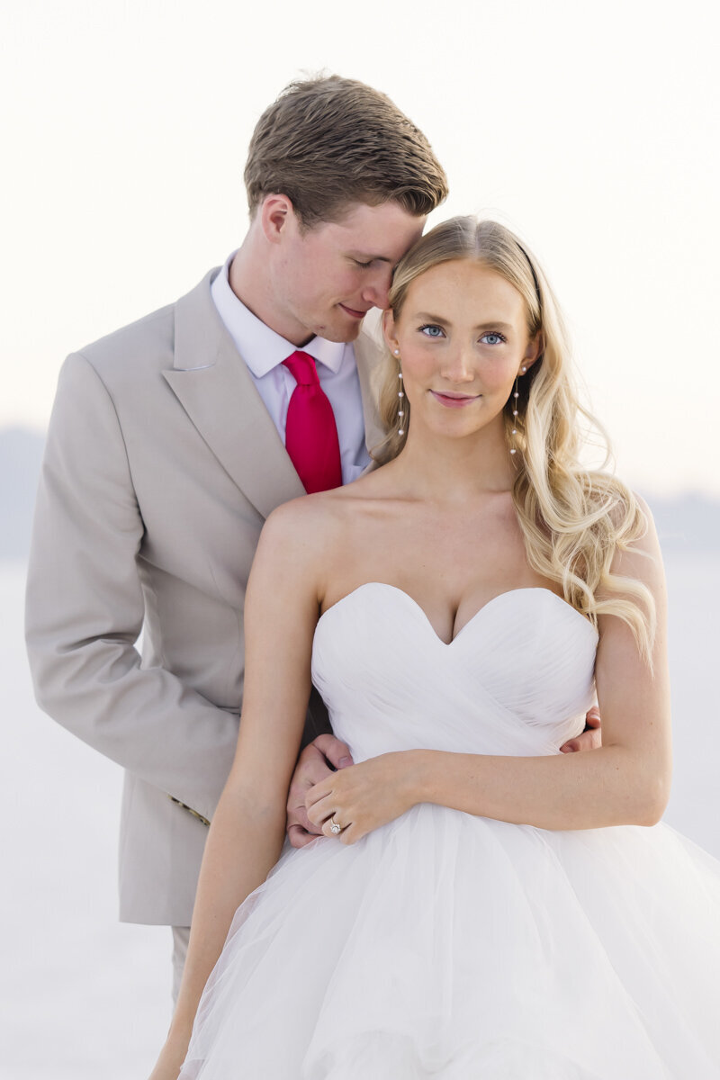 bride and groom embracing while gently smiling