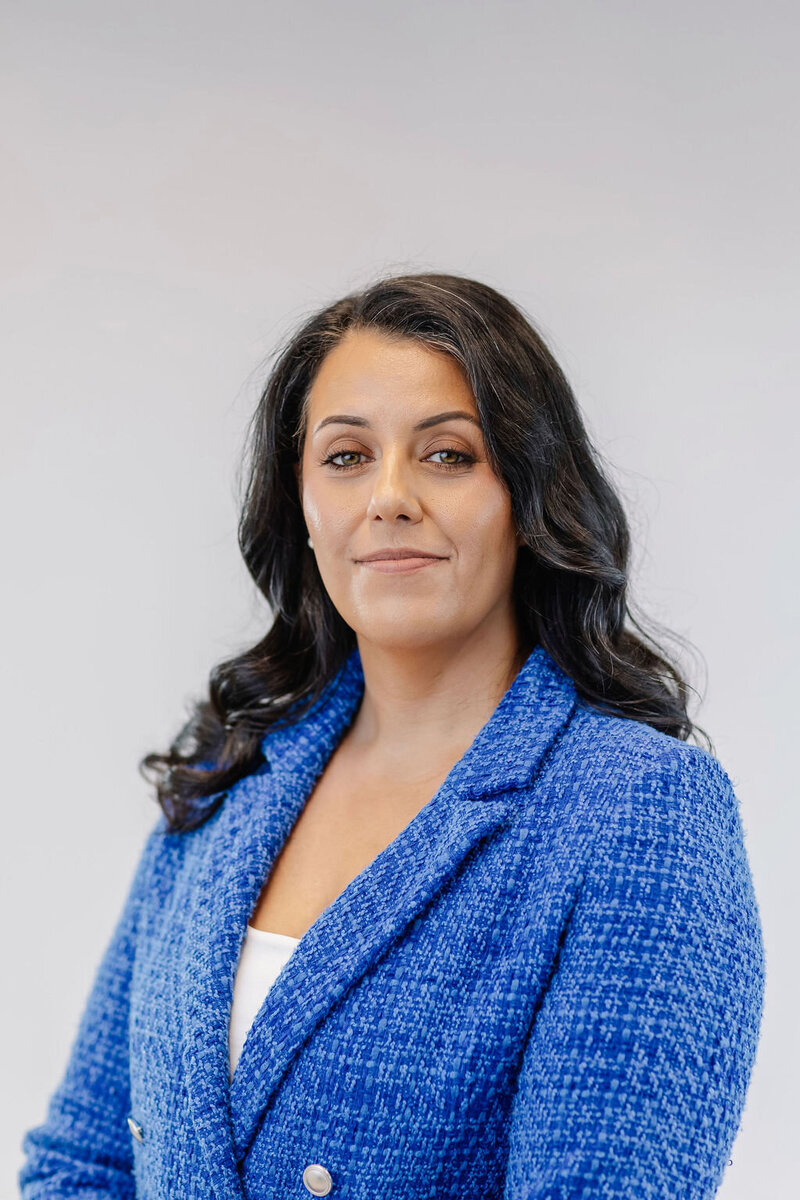 portrait of a woman with dark hair and a blue blazer