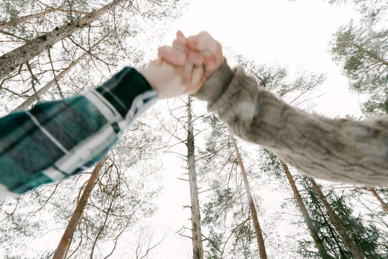 Kihlapari metsässä talvisessa kihlakuvauksessa valokuvaaja Hannika Gabrielssonin ottamassa valokuvassa