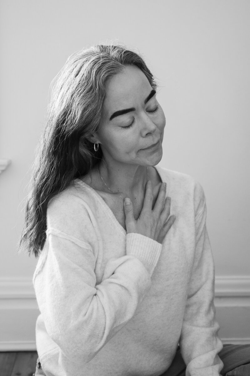 Dr. Tanner Wallace, founder of CPTSD Medicine, sitting on a wooden floor and smiling softly, representing calm self-awareness and healing from relationship red flags.
