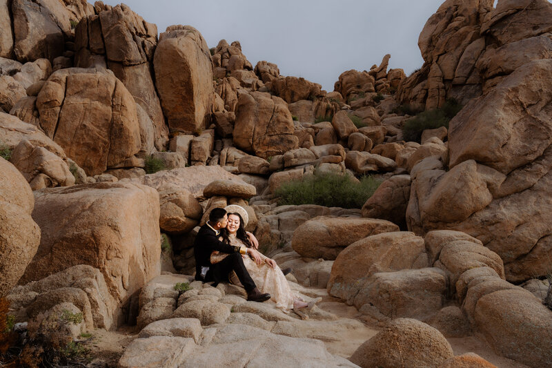 Joshua Tree Elopement with Asian couple at Hidden Valley Jumbo Rocks kissing.