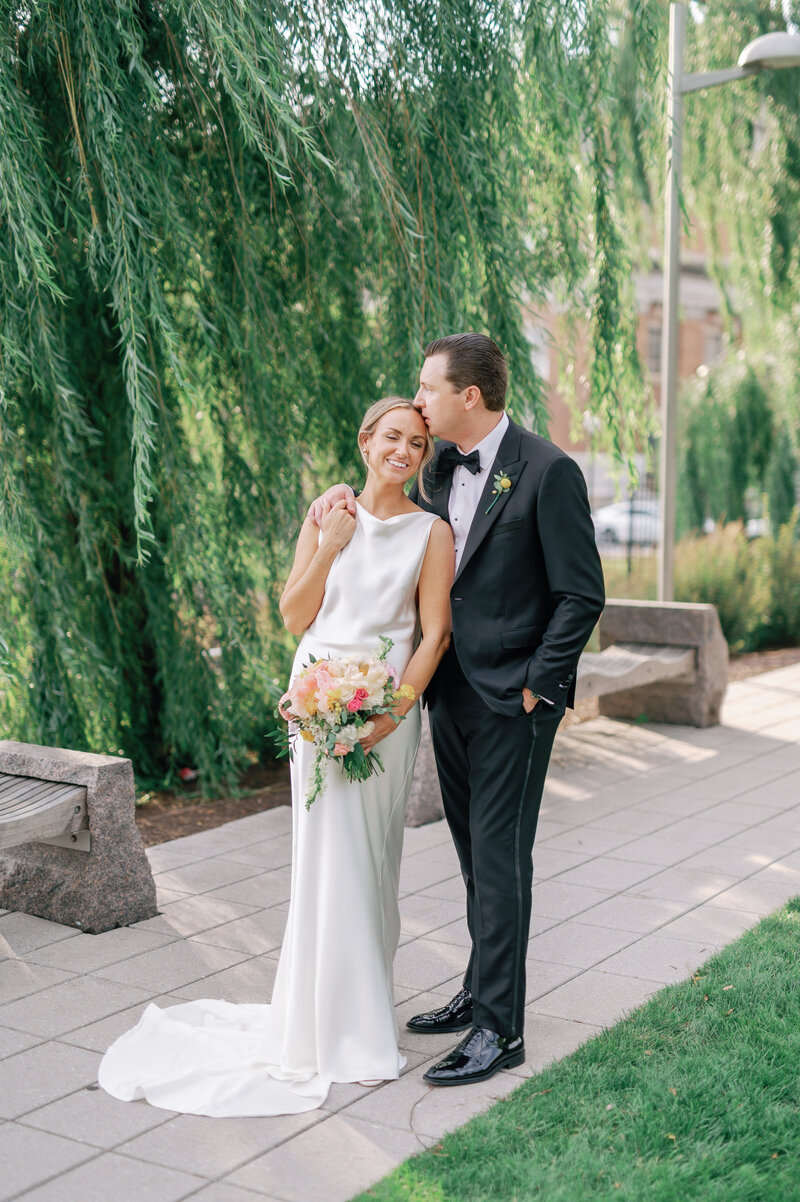 Groom kissing bride's forehead