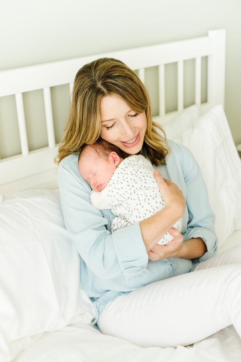 Mother holding her sleeping newborn, captured by Tevi Hardy, Bay Area newborn photographer.