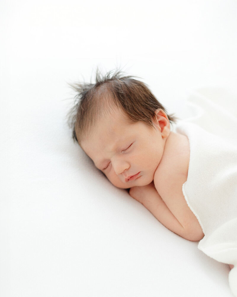 newborn baby sleeping on her belly