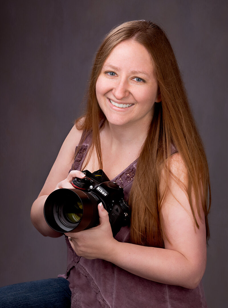 Professional and approachable headshot featuring a photographer specializing in newborn, maternity, and family photography in Overland Park, Kansas. Showcasing creativity and a personalized approach for families in the Kansas City metro area.