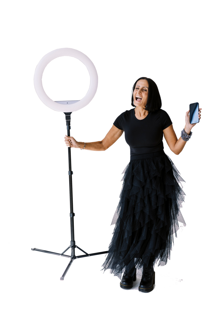 Cut out of Tarah wearing a black tool dress holding stage light