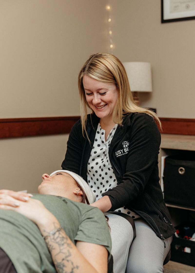 Chiropractor Brittany Fisk adjusting a patient’s neck during a gentle chiropractic session at Busy Bee Chiropractic.