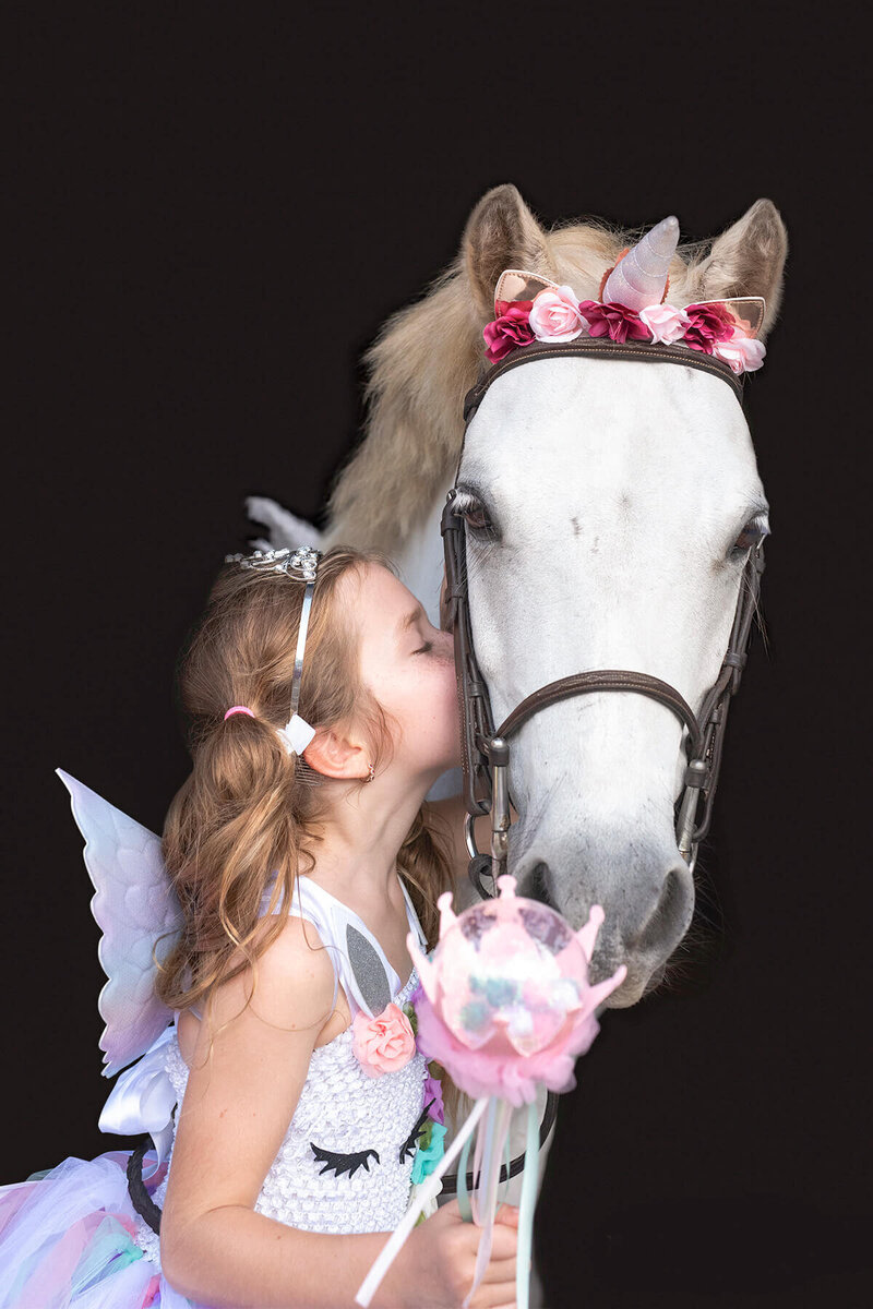 kissimmee florida photography of a. girl kissing her white pony on a black background