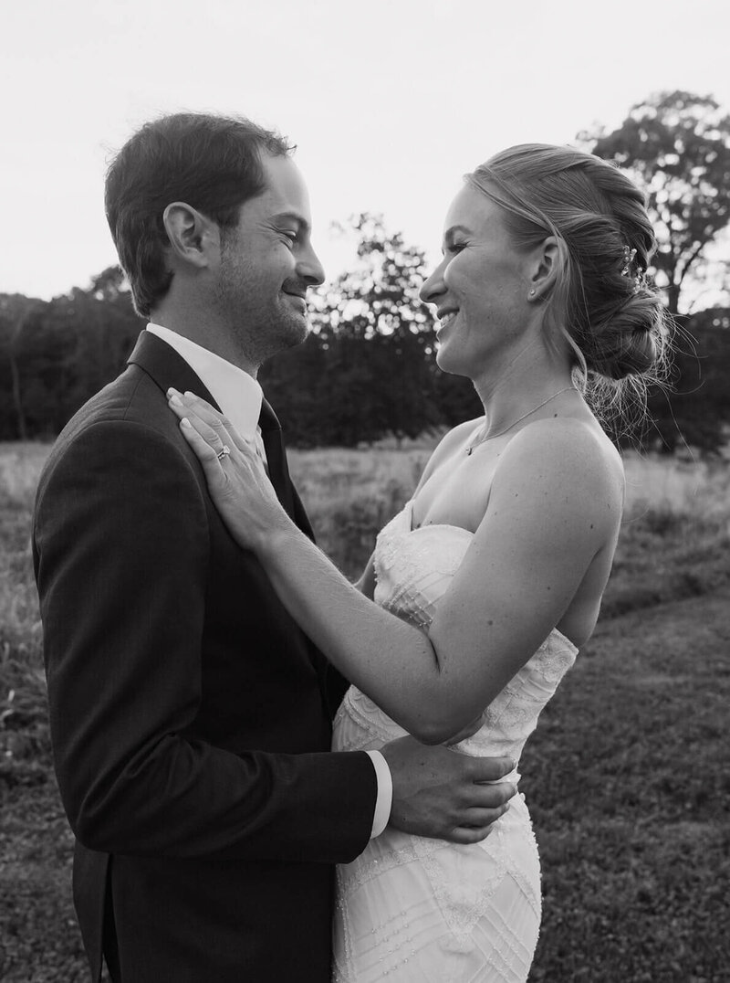 The groom and bride are embracing and looking at each other.