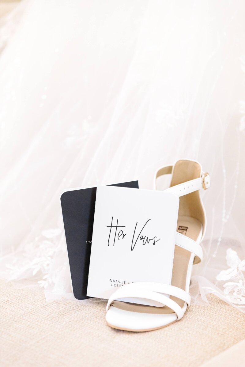 His and her vow booklets are placed in the bride's shoe.