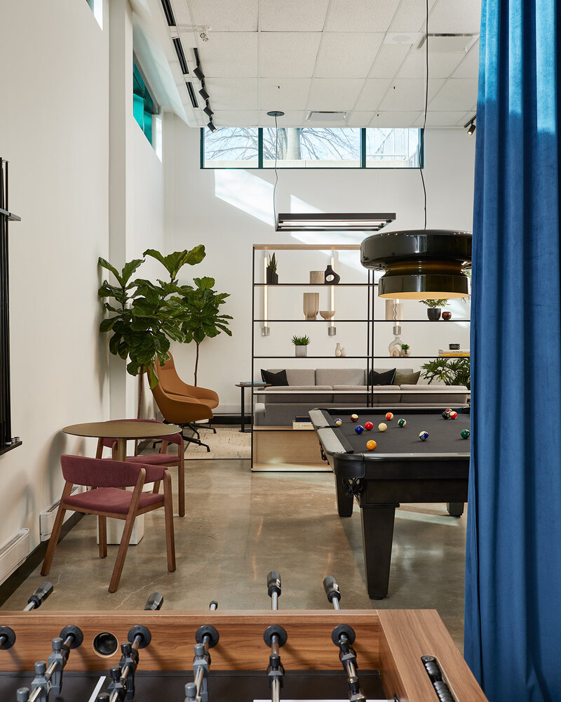 A vibrant lounge featuring foosball and pool tables and elegantly  decorated seating areas