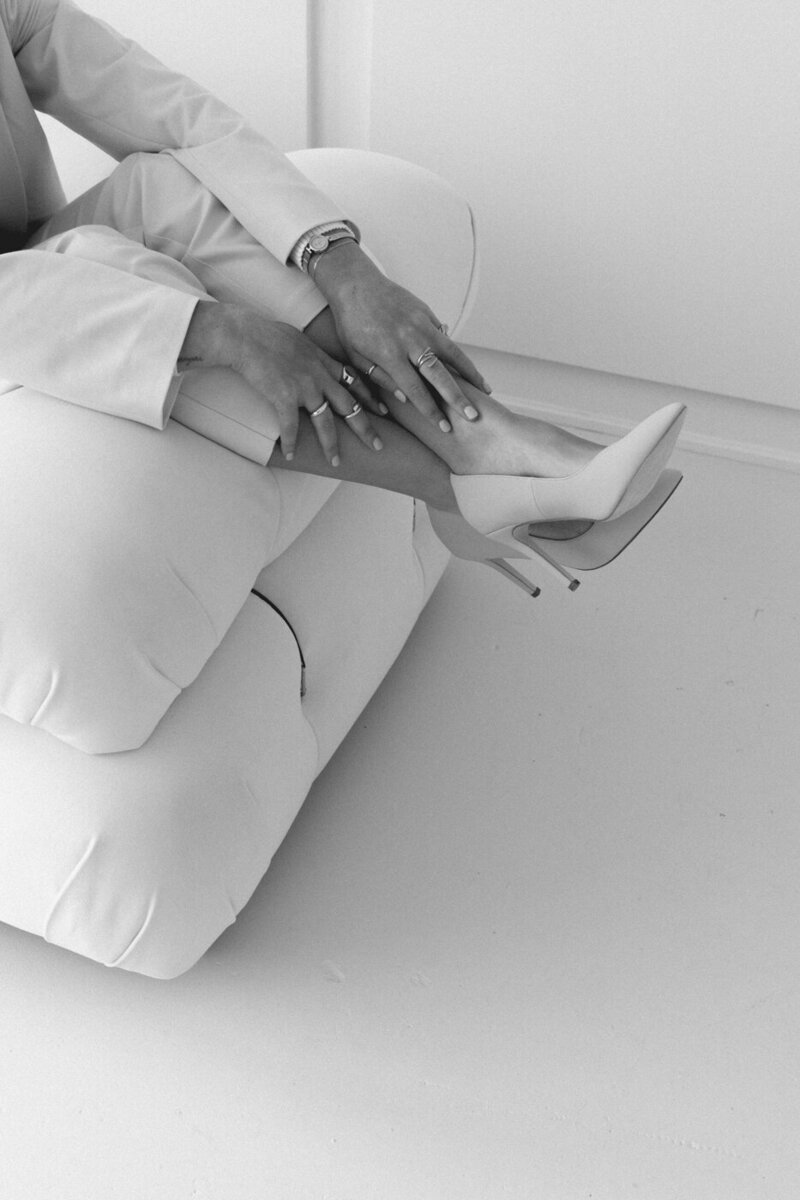 black and whit image of a business woman on a comfy chair with high heels