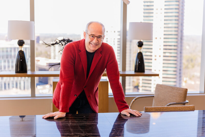 Ahmet Bozer standing on a bridge, hand resting on the handrail, wearing a sleeveless jacket during his outdoor personal brand session in Buckhead Atlanta