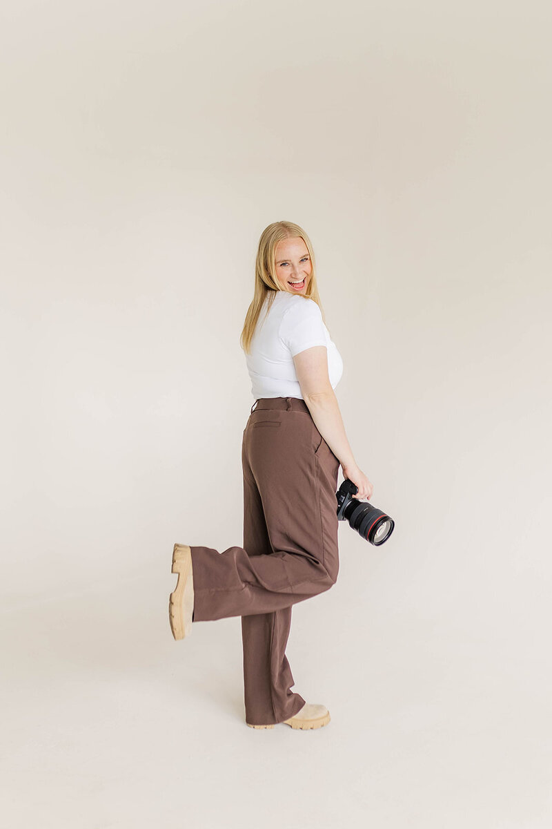 Jessica Nicole Photography smiling holding her camera ready to photograph your Colorado wedding.