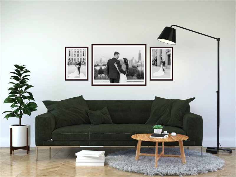 framed black and white wedding photos hang above green sofa