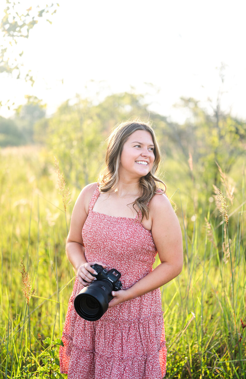 woman smiling while holding her camera