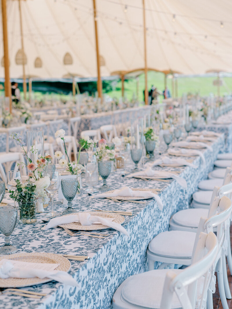 Close up of a blue and white wedding reception with pops of green and dainty florals