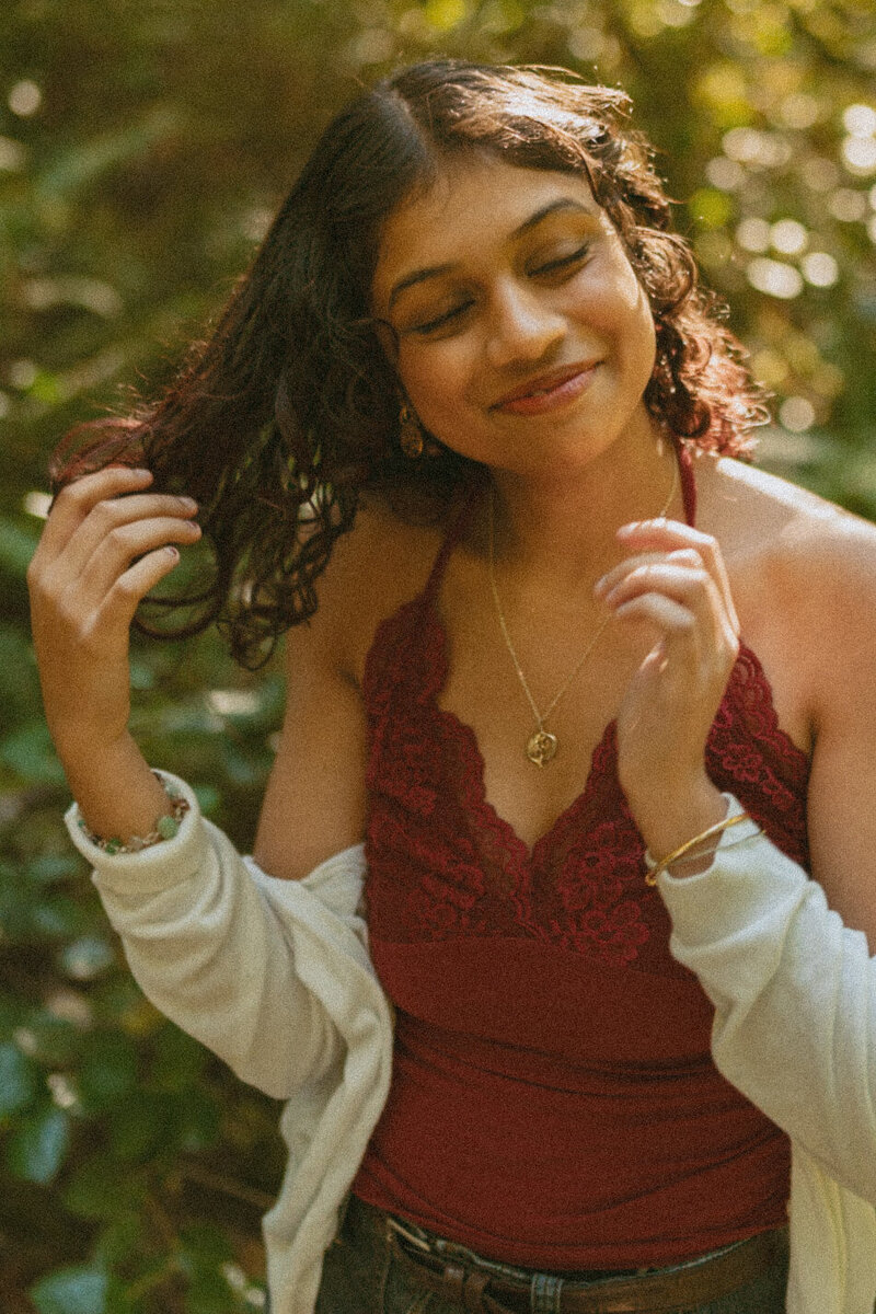 girl in white dress sitting among forest ferns