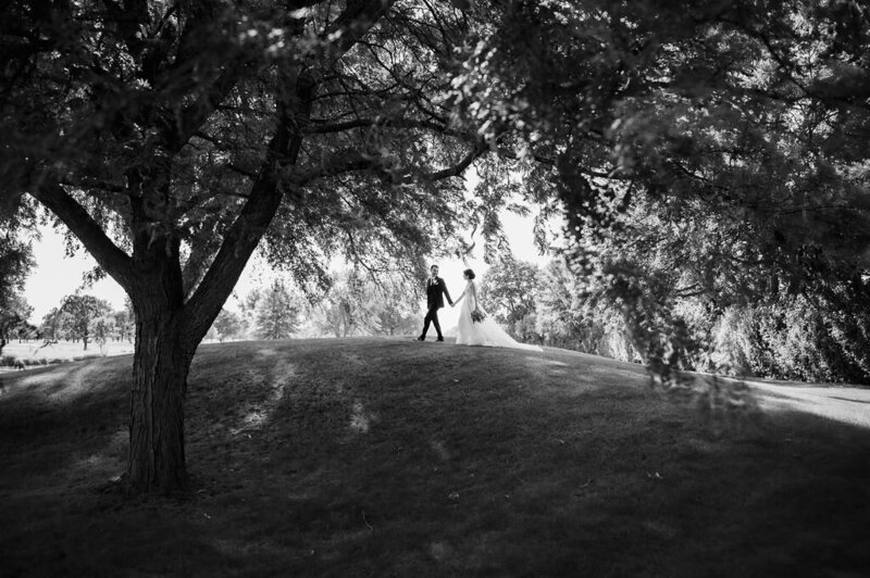 Bride and groom walk on a hill  at Chevy Chase Country Club in Wheeling, IL