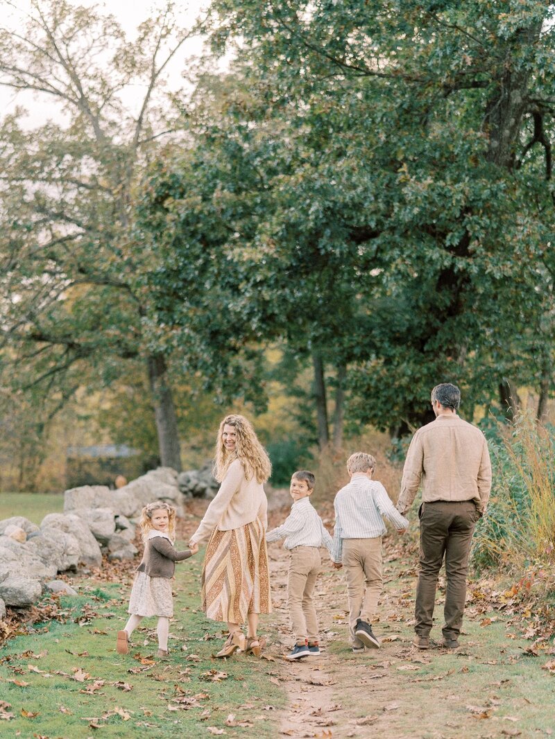 Family walking together holding hands and looking back at the camera