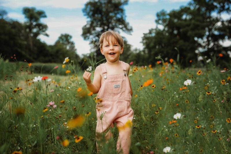Toddler walks in a field of wild flowers during Family Photos at the NC Arboretum in Asheville, NC.