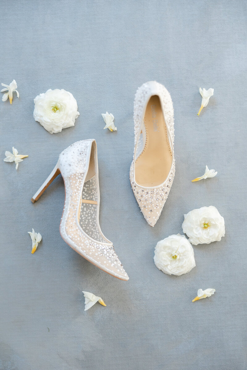 bella belle bridal shoe flat lay with flowers sprinkled around