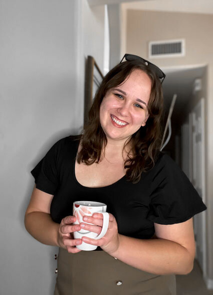 meg vick holding cup of coffee and smiling